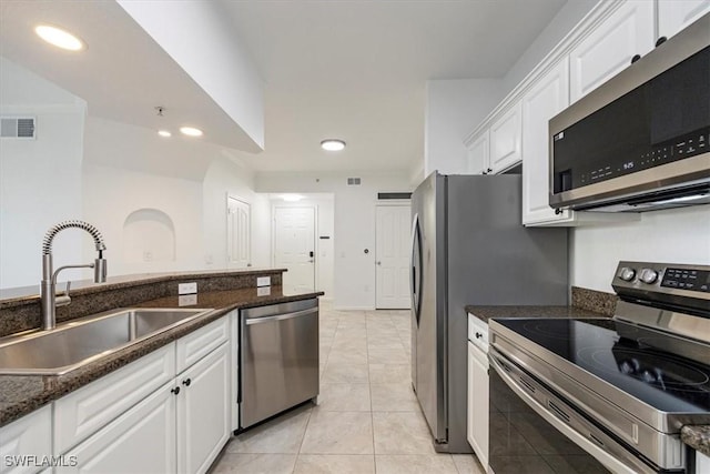 12980 Positano Cir Unit 306, Naples, FL 34105 - kitchen featuring stainless steel appliances, white cabinets, recessed lighting, light tile patterned floors, and dark stone counters