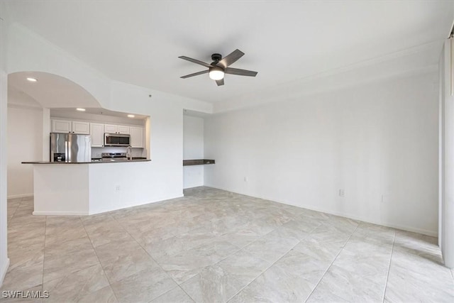12980 Positano Cir Unit 306, Naples, FL 34105 - unfurnished living room with a ceiling fan, arched walkways, recessed lighting, and ornamental molding