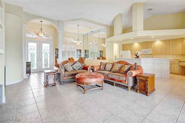 3206 SW 4th Ln, Cape Coral, FL 33991 - living room featuring french doors, light tile patterned floors, high vaulted ceiling, decorative columns, and a chandelier