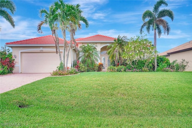 3206 SW 4th Ln, Cape Coral, FL 33991 - mediterranean / spanish-style home featuring a garage, a front lawn, stucco siding, and driveway