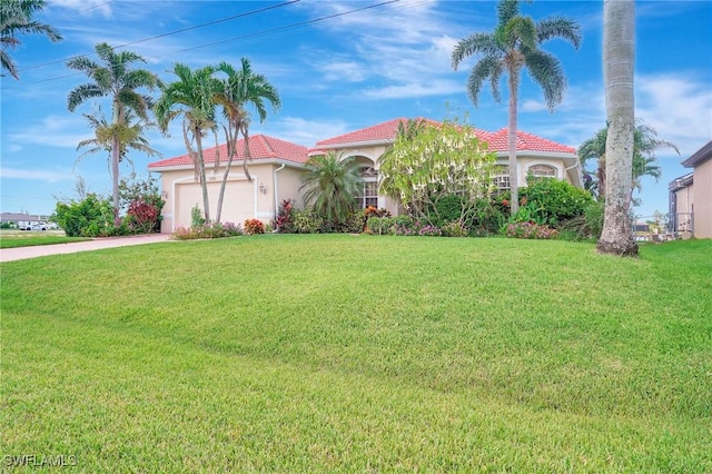 3206 SW 4th Ln, Cape Coral, FL 33991 - mediterranean / spanish-style home with a garage, a tile roof, a front yard, stucco siding, and driveway