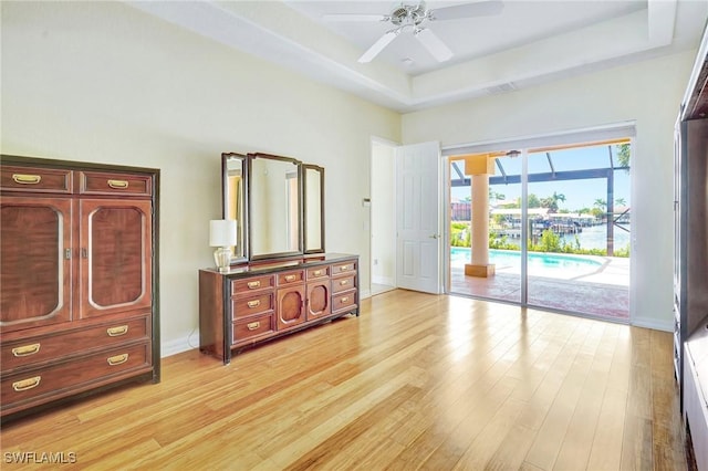 3206 SW 4th Ln, Cape Coral, FL 33991 - bedroom featuring access to outside, light wood-style flooring, a tray ceiling, a ceiling fan, and a high ceiling