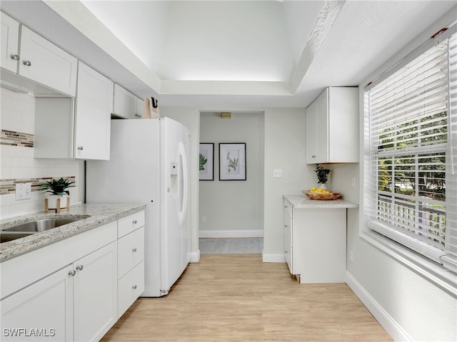1492 La Petite Ct, Naples, FL 34104 - kitchen with white cabinetry, decorative backsplash, and light wood-type flooring