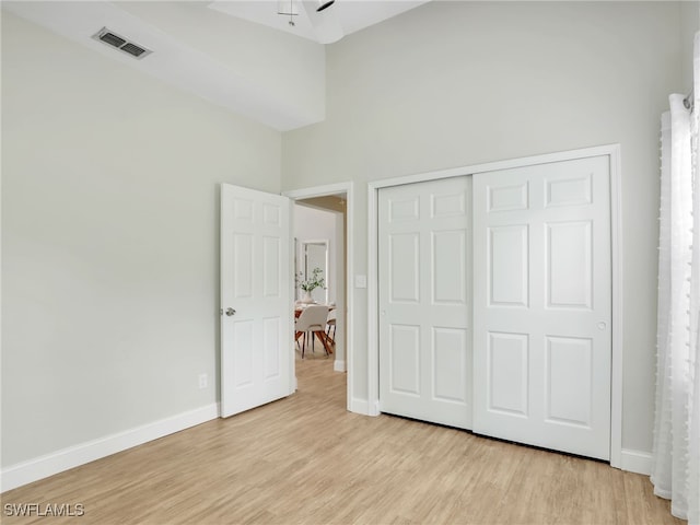 1492 La Petite Ct, Naples, FL 34104 - unfurnished bedroom featuring light wood finished floors, a high ceiling, and a closet