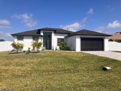 1905 SW 3rd St, Cape Coral, FL 33991 - prairie-style home featuring a garage, decorative driveway, and stucco siding