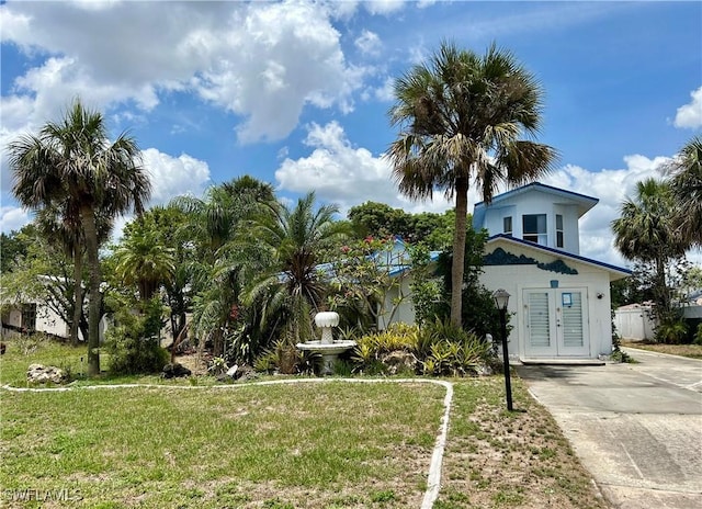 211 Oakmont Pkwy, Lehigh Acres, FL 33936 - view of front facade featuring french doors, a front yard, and concrete driveway