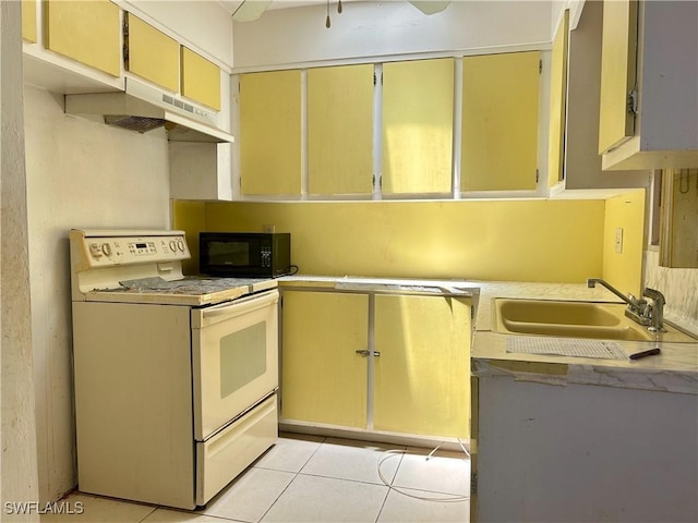211 Oakmont Pkwy, Lehigh Acres, FL 33936 - kitchen with white range with electric cooktop, black microwave, under cabinet range hood, light tile patterned floors, and cream cabinetry