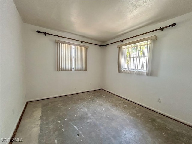 211 Oakmont Pkwy, Lehigh Acres, FL 33936 - spare room featuring baseboards and concrete flooring