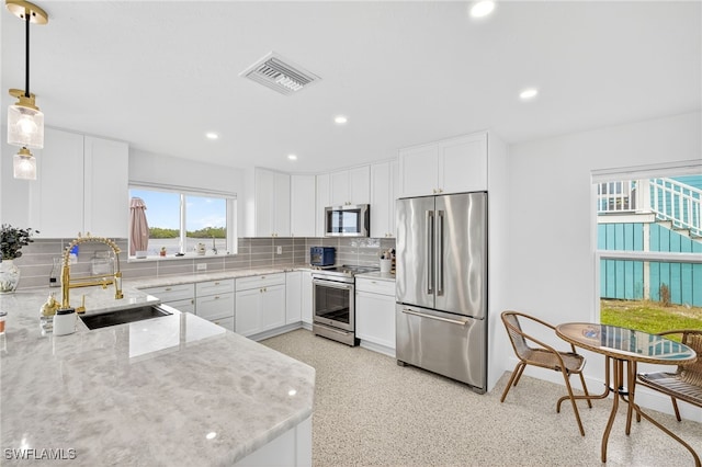 867 Oak St, Fort Myers Beach, FL 33931 - kitchen with stainless steel appliances, light stone countertops, backsplash, white cabinetry, and recessed lighting