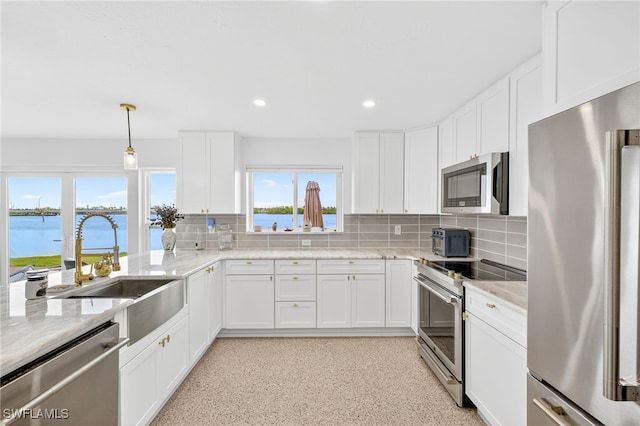 867 Oak St, Fort Myers Beach, FL 33931 - kitchen featuring appliances with stainless steel finishes, tasteful backsplash, light stone counters, white cabinetry, and recessed lighting