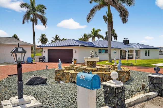 867 Oak St, Fort Myers Beach, FL 33931 - single story home featuring a garage, driveway, a metal roof, stucco siding, and a chimney