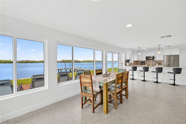 867 Oak St, Fort Myers Beach, FL 33931 - dining area with dark aggregate flooring, recessed lighting, and a water view