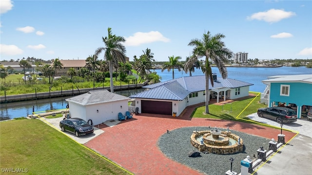 867 Oak St, Fort Myers Beach, FL 33931 - view of front of home with a front lawn, a water view, driveway, a garage, and stucco siding