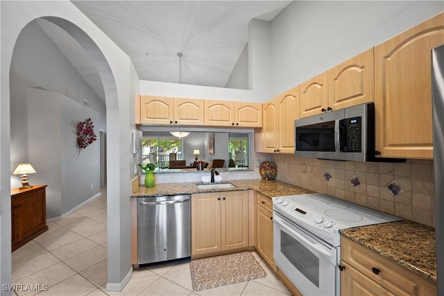 2456 Millcreek Ln Unit 201, Naples, FL 34119 - kitchen with appliances with stainless steel finishes, light brown cabinets, light tile patterned flooring, tasteful backsplash, and high vaulted ceiling