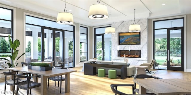 8787 Oceana Way, Naples, FL 34114 - dining area with a premium fireplace, light wood-style floors, and a raised ceiling