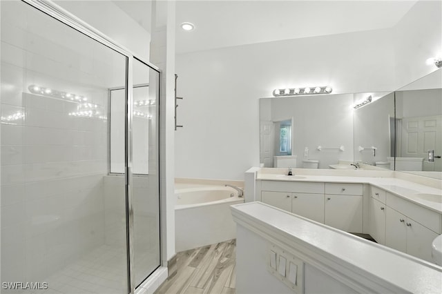 1000 L Ambiance Cir Unit 205, Naples, FL 34108 - full bathroom featuring a bath, a stall shower, double vanity, and wood finished floors