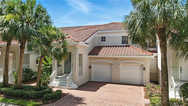 1000 L Ambiance Cir Unit 205, Naples, FL 34108 - mediterranean / spanish home with an attached garage, decorative driveway, stucco siding, and a tiled roof