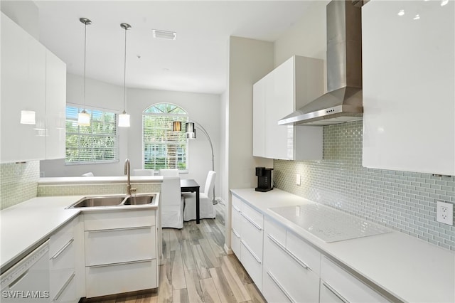 1000 L Ambiance Cir Unit 205, Naples, FL 34108 - kitchen with wall chimney exhaust hood, electric cooktop, white dishwasher, light wood finished floors, and white cabinets