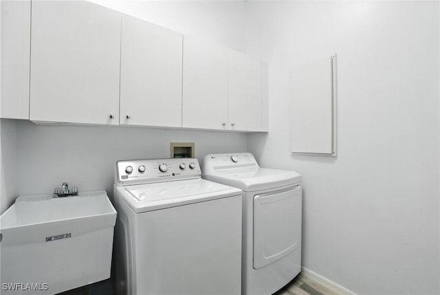 1000 L Ambiance Cir Unit 205, Naples, FL 34108 - washroom featuring washing machine and clothes dryer, cabinet space, and wood finished floors