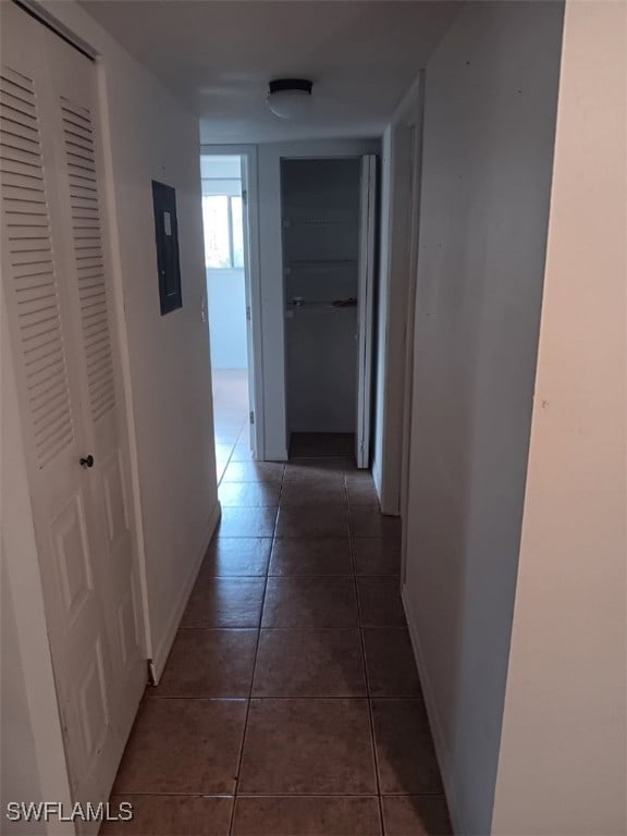 hall with tile patterned floors and electric panel