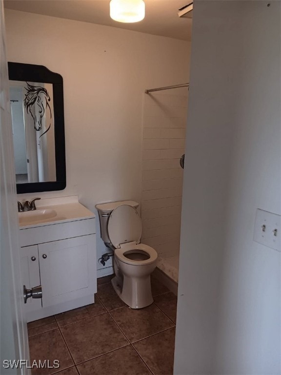 bathroom featuring tile patterned flooring, vanity, and tiled shower