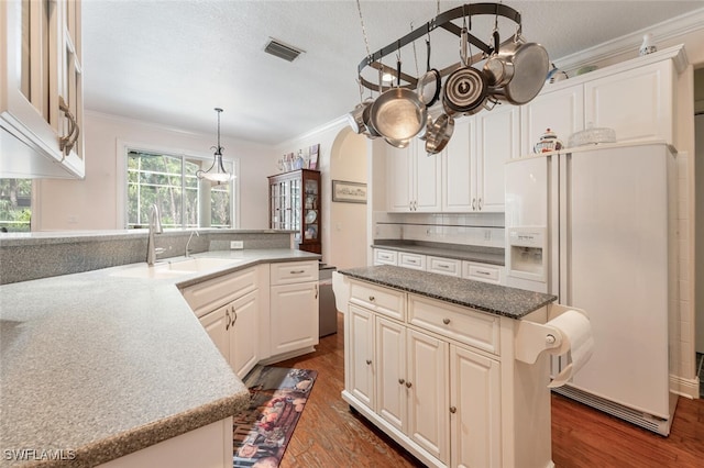 13915 Collier Blvd, Naples, FL 34119 - kitchen with white fridge with ice dispenser, crown molding, decorative backsplash, dark wood-type flooring, and white cabinetry