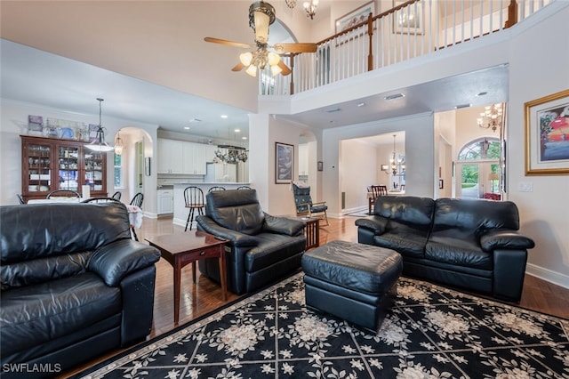 13915 Collier Blvd, Naples, FL 34119 - living area featuring a chandelier, arched walkways, a ceiling fan, wood finished floors, and a high ceiling
