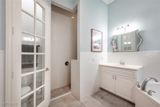 13915 Collier Blvd, Naples, FL 34119 - full bathroom featuring tile walls, tile patterned floors, vanity, a garden tub, and a wainscoted wall