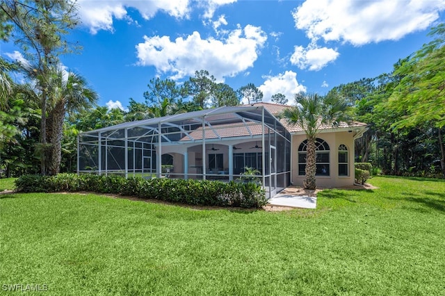 13915 Collier Blvd, Naples, FL 34119 - back of property featuring a ceiling fan, a yard, stucco siding, a lanai, and a tile roof
