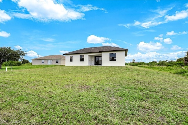 147 Partridge St, Lehigh Acres, FL 33974 - back of property featuring stucco siding and a yard