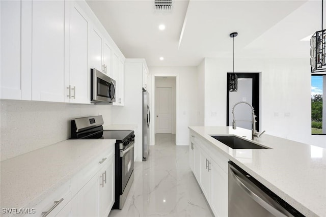 147 Partridge St, Lehigh Acres, FL 33974 - kitchen with stainless steel appliances, light marble finish floors, recessed lighting, white cabinets, and light stone countertops