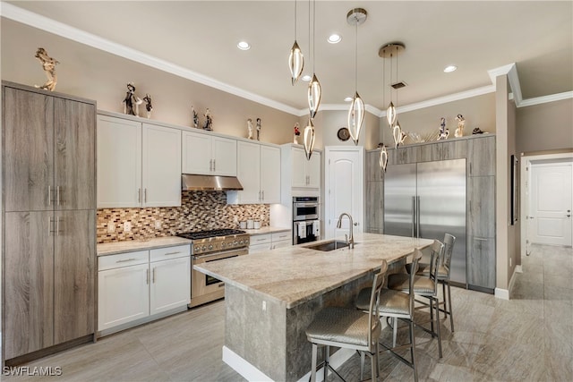 7478 Winding Cypress Dr, Naples, FL 34114 - kitchen with high quality appliances, crown molding, decorative backsplash, a breakfast bar area, and under cabinet range hood