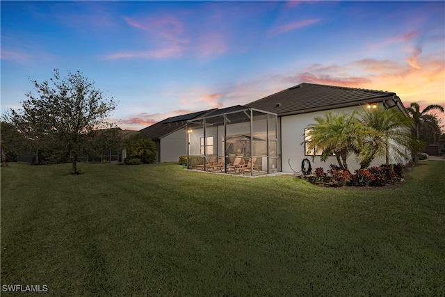 7478 Winding Cypress Dr, Naples, FL 34114 - back of property at dusk with a yard and a lanai
