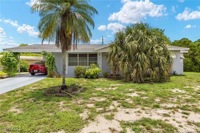 326 Canyon Dr N, Lehigh Acres, FL 33936 - view of front facade with concrete driveway, stucco siding, a front yard, and a carport