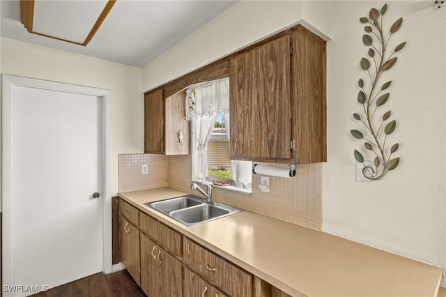 326 Canyon Dr N, Lehigh Acres, FL 33936 - kitchen with light countertops, tasteful backsplash, dark wood-type flooring, and brown cabinetry