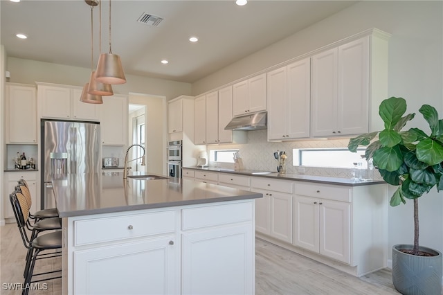 4442 Battlecreek Way, Ave Maria, FL 34142 - kitchen featuring under cabinet range hood, appliances with stainless steel finishes, decorative backsplash, light wood finished floors, and recessed lighting