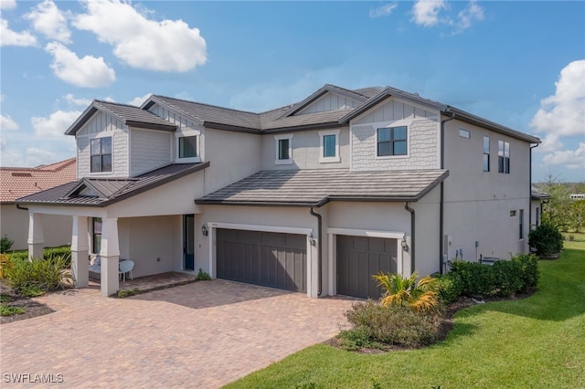 4442 Battlecreek Way, Ave Maria, FL 34142 - view of front of house featuring an attached garage, a standing seam roof, stucco siding, a front yard, and decorative driveway