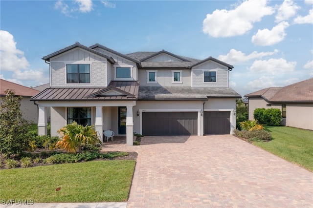 4442 Battlecreek Way, Ave Maria, FL 34142 - craftsman-style home featuring an attached garage, a standing seam roof, decorative driveway, a front yard, and stucco siding