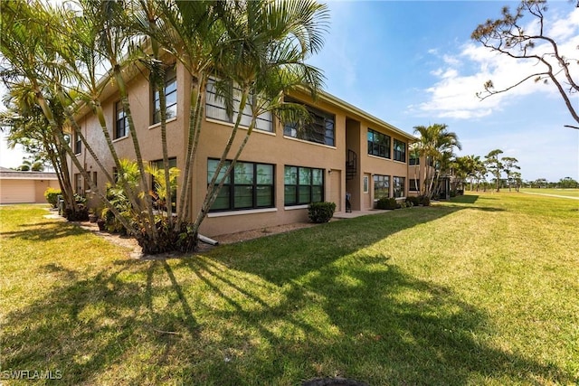 2127 SW Pine Ln Unit 3, Cape Coral, FL 33991 - rear view of property with stucco siding and a lawn