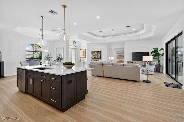 7637 Mulberry Ln, Naples, FL 34114 - kitchen featuring a raised ceiling, light wood finished floors, light countertops, dark brown cabinetry, and crown molding