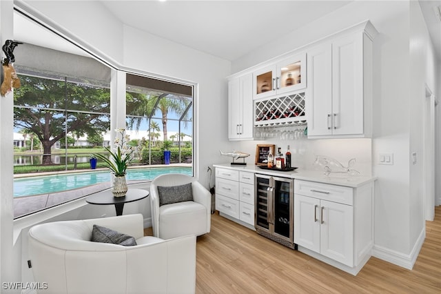 7637 Mulberry Ln, Naples, FL 34114 - indoor dry bar with wine cooler and light wood-type flooring