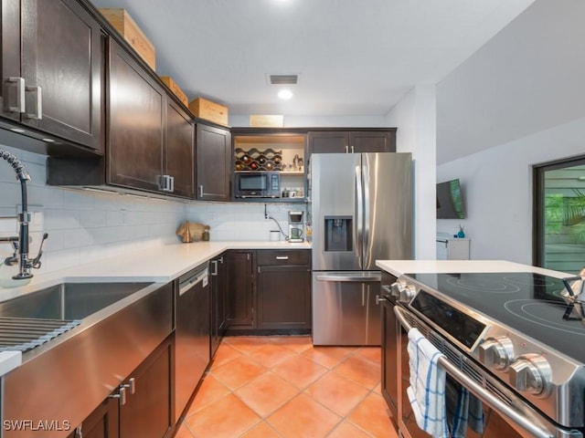 1271 Solana Rd Unit E4, Naples, FL 34103 - kitchen featuring appliances with stainless steel finishes, dark brown cabinetry, backsplash, light tile patterned floors, and open shelves