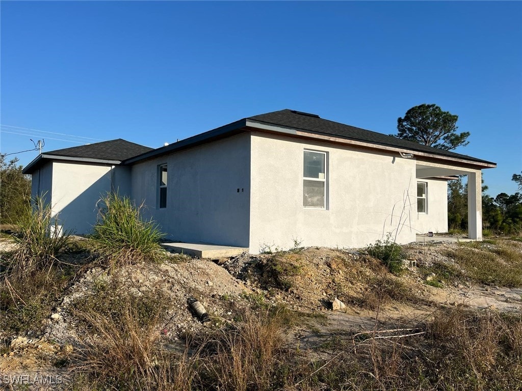 716 Joponica Ave S, Lehigh Acres, FL 33974 - view of side of home with stucco siding