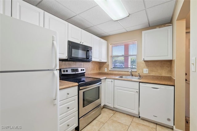 170 Turtle Lake Ct Unit 109, Naples, FL 34105 - kitchen featuring white appliances, white cabinets, a drop ceiling, tasteful backsplash, and light tile patterned floors