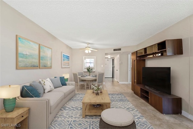 170 Turtle Lake Ct Unit 109, Naples, FL 34105 - living area featuring ceiling fan, a textured ceiling, and light tile patterned flooring