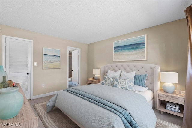 170 Turtle Lake Ct Unit 109, Naples, FL 34105 - bedroom with a textured ceiling and ensuite bath