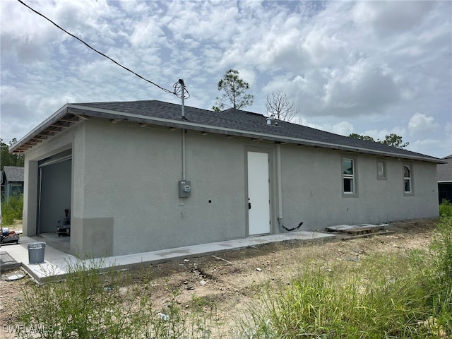 479 Windermere Dr, Lehigh Acres, FL 33972 - rear view of house with stucco siding and roof with shingles
