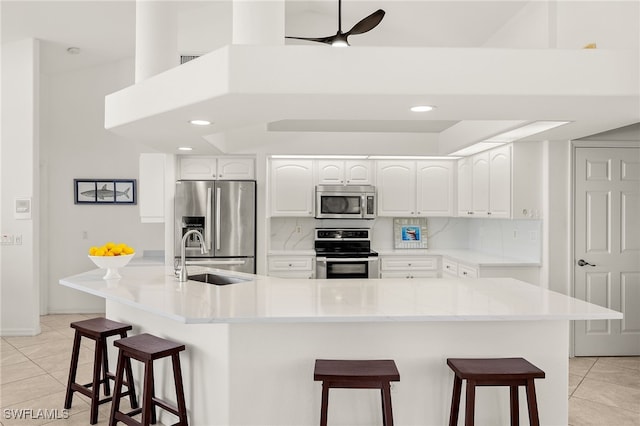 3615 Tripoli Blvd, Punta Gorda, FL 33950 - kitchen featuring stainless steel appliances, light tile patterned flooring, a breakfast bar area, white cabinets, and recessed lighting