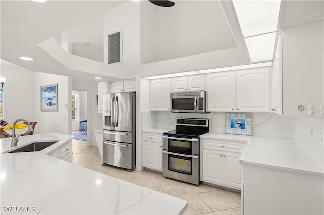 3615 Tripoli Blvd, Punta Gorda, FL 33950 - kitchen featuring appliances with stainless steel finishes, light tile patterned floors, light stone countertops, white cabinetry, and recessed lighting