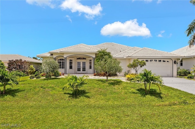 3615 Tripoli Blvd, Punta Gorda, FL 33950 - mediterranean / spanish-style home with french doors, an attached garage, a front lawn, and driveway